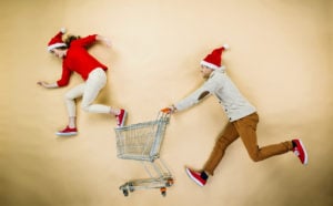 bigstock-Christmas-couple-with-trolley-75357352-300x186