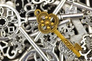 bigstock-Golden-antique-key-on-pile-of-88213061-300x200
